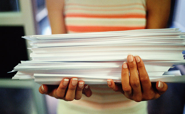 Woman holding a stack of paper